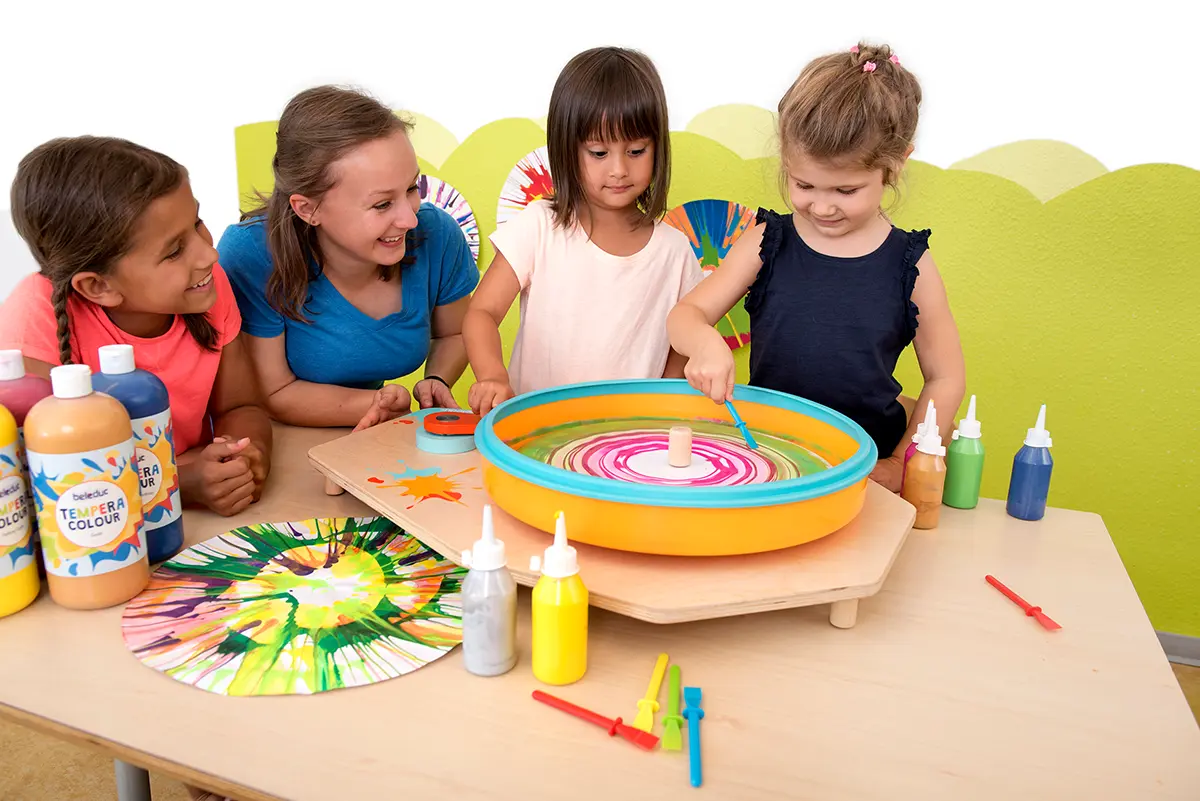 Kind ist kreativ mit der Farbschleuder